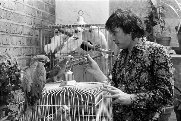 Fashion photographer David Bailey pictured at home with some of his 40 parrots