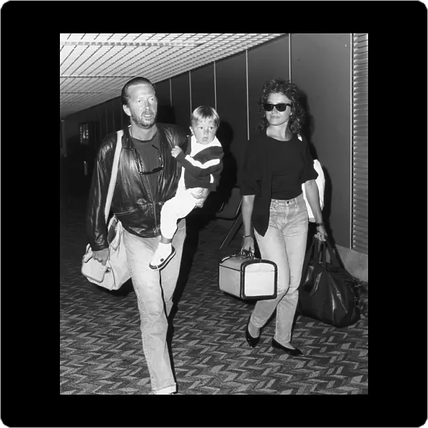 Eric Clapton singer songwriter and girlfriend Lori Del Santo walk through airport with