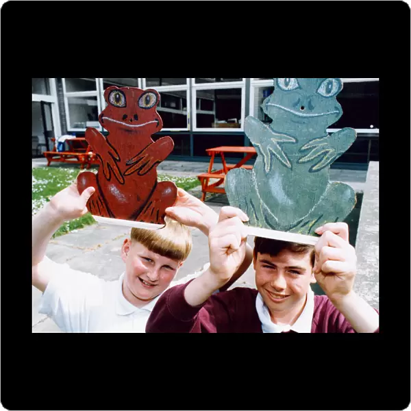 Pupils at Eston Park School with two of the frogs which are too be used in a frog race to