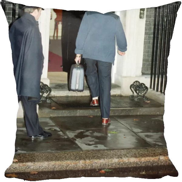 Denis Thatcher carries a suitcase into 10 Downing Street following the Prime Minister