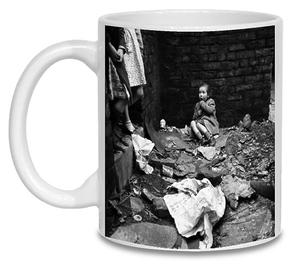 Slum housing in Salford. Four year old Lyn Greenhalgh. The rubble is hers to play with