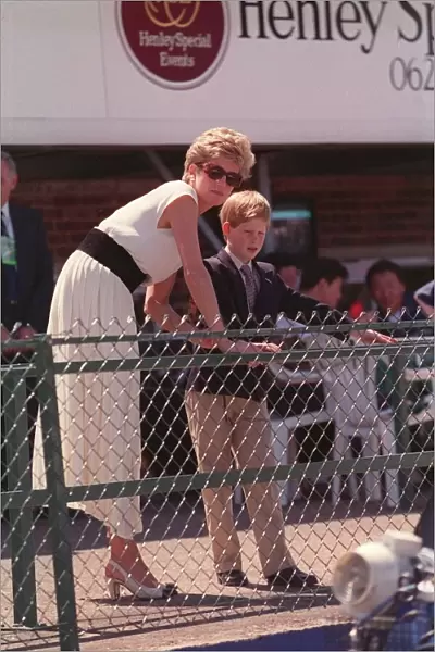 PRINCESS DIANA WEARING A WHITE DRESS AND PRINCE HARRY, STANDING BEHIND AND LOOKING OVER