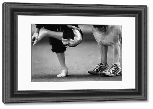 Picture shows a dog wearing trainers presumably belonging to the young boy on the left