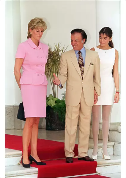 PRINCESS DIANA WEARING A PINK SUIT AND BLACK SHOES STANDING NEXT TO CARLOS MENEM
