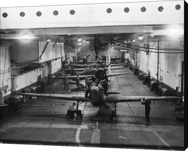Mechanics working on the British Royal Navy aircraft carrier HMS Argus inside the hangar