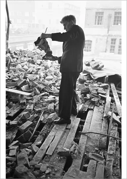 A member of staff holds a damaged instrument amongst the rubble of The Westminster