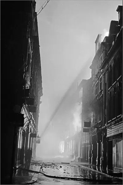 Firemen tackling fires in Ave Maria Lane, London, started by high explosive