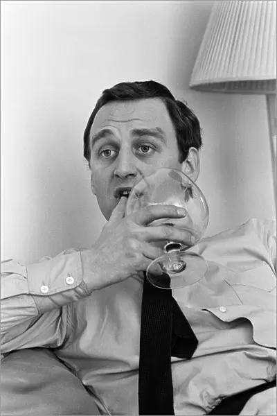 Actor John Thaw relaxing at home in London with a brandy. 30th March 1966