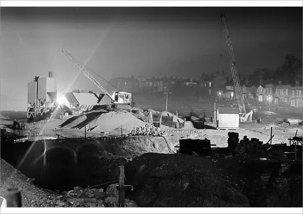 Silent cranes reach over what is usually a scene of intense activity by day - the site of