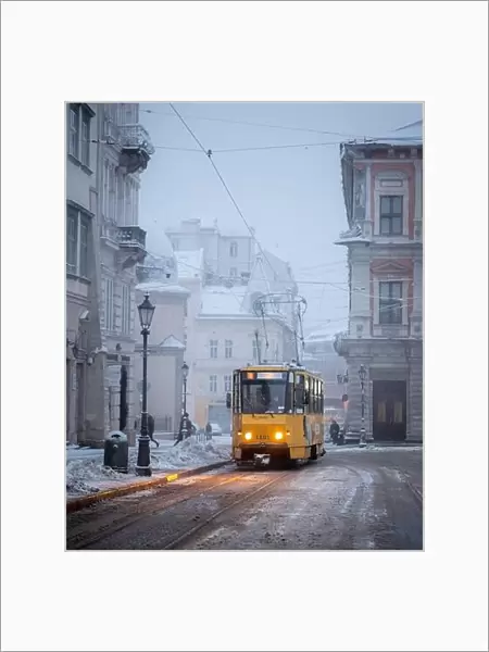 Yellow tram on Market central square in winter Lviv city, Ukraine, Europe. Morning cityscape