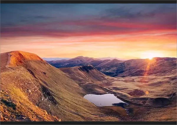 Mountain lake on sunrise time. Picturesque autumn landscape with sun in morning sky, Carpathian mountains