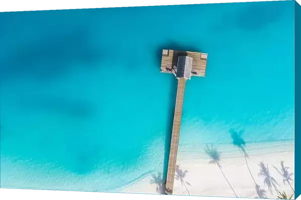 Beautiful aerial view of poolside and resort beach with wooden pier jetty. Luxurious tropical beach landscape, swimming, ocean lagoon