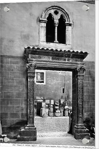 View of the portal with decorated frames with candlestick motifs. In the upper part of the masonry, a window with two lights and an arch with three sections, located in the National Museum of Abruzzo, L'Aquila