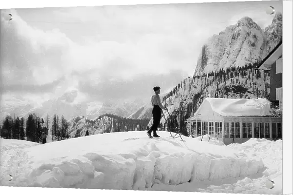 Skier next to the Tre Cime ski lodge in Lavaredo with a mountain landscape in the background