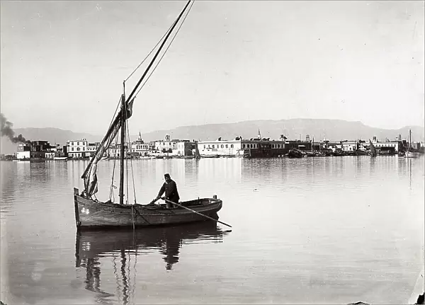 Panoramic view of a town on the Suez Canal, in Egypt. A man is photographed on board a boat