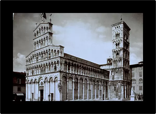 Facade, one side and Campanile of San Michele in Lucca. To the right the marble statue of Francesco Burlamacchi can be seen