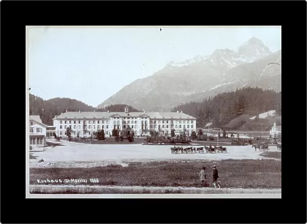 A spa clinic at Saint-Moritz. In the background the swiss Alps. A few carriages are parked in front of the spa