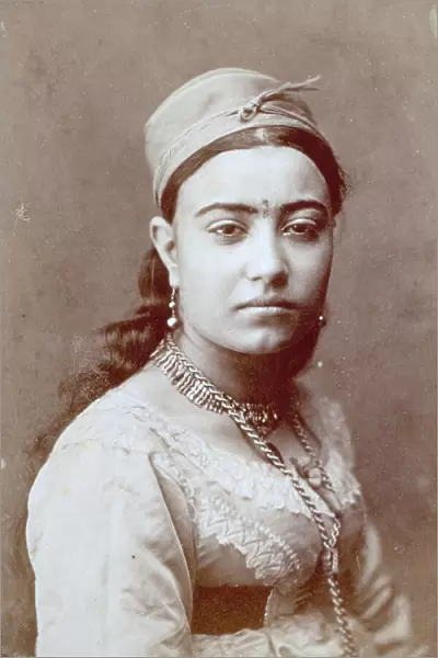 Half-length portait of an arab woman, she is wearing traditional dress and jewellery