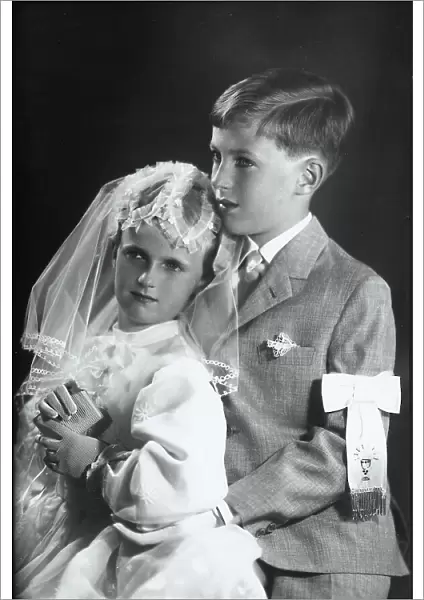 Two children embracing, wearing communion clothing