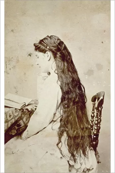 Portrait of young woman with her back to the camera. Her hair is loose and very long