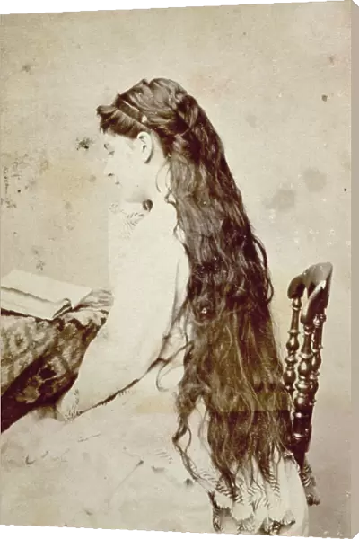 Portrait of young woman with her back to the camera. Her hair is loose and very long