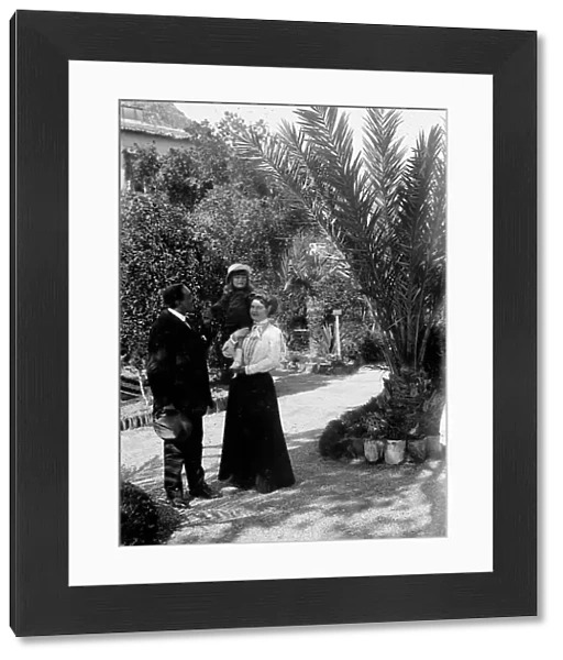 Portrait of couple with a child in a garden in Taormina