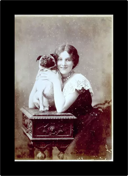 Studio portrait of young woman embracing a puppy placed on a small table