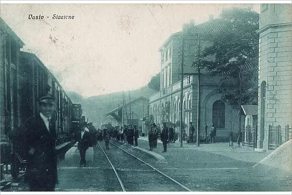 Railway station of Vasto: people waiting near a track while a train runs on the opposite track