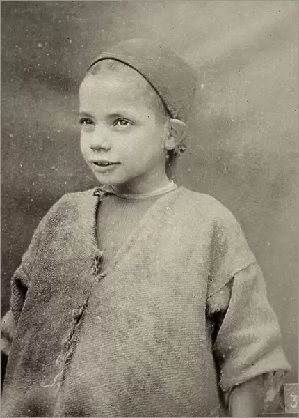 The image shows a Tunisian child portrait: the child wears a cap