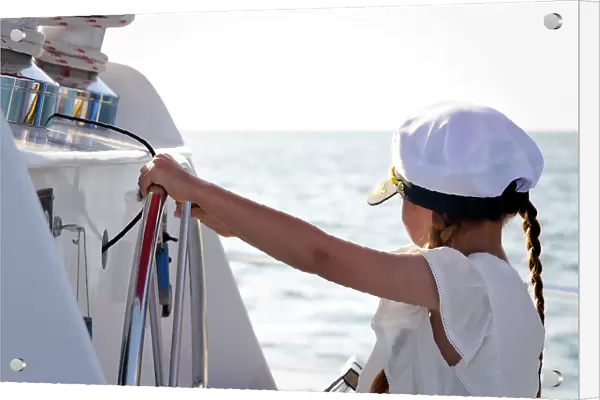 Little girl at helm wearing captain hat