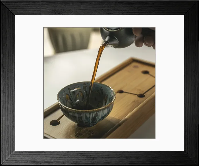 Framed Print : Fragrant Tea Pouring into Handcrafted Cup Print Framed Print : Fragrant Tea Pouring into Handcrafted Cup Print