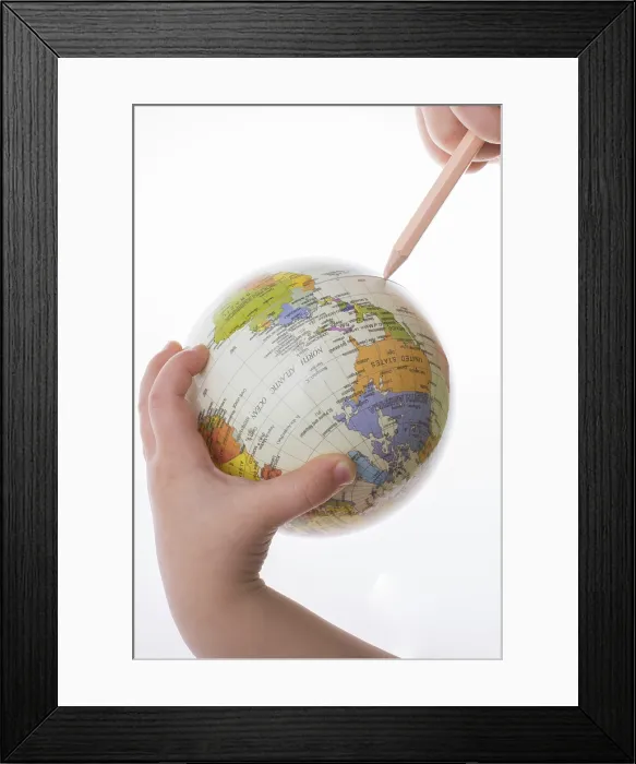 Framed Print : Child holding a globe and pen print on white background Framed Print : Child holding a globe and pen print on white background