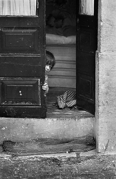 Child peeping round door, Lisbon