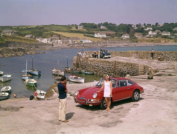 Couple with red car at Coverack, Cornwall