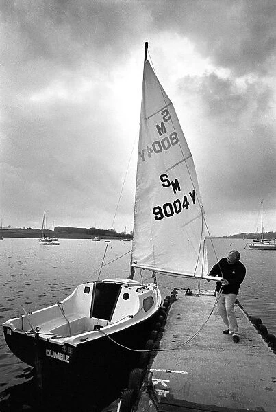A sailor prepares his small yacht for a sail on Rutland Wate