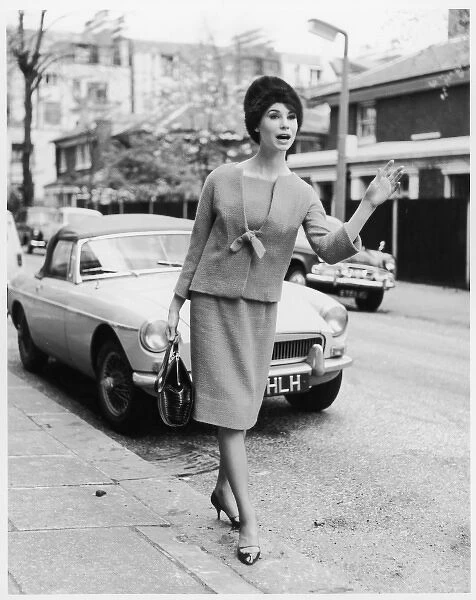 TAXI. A woman in smart stylish suit of straight knee-length skirt & a collarless