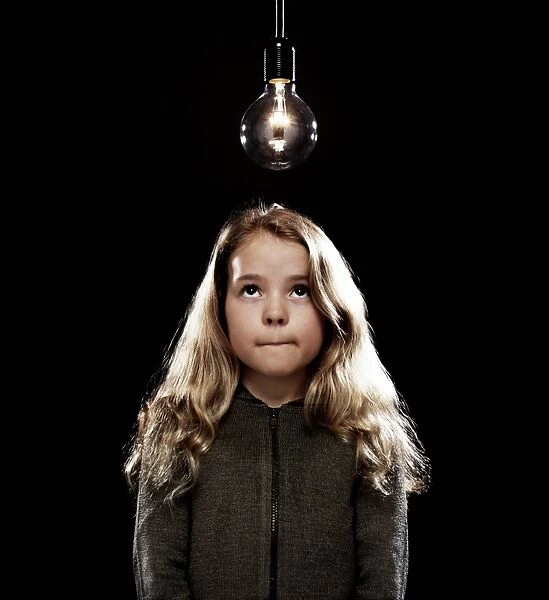 Girl standing beneath a lightbulb