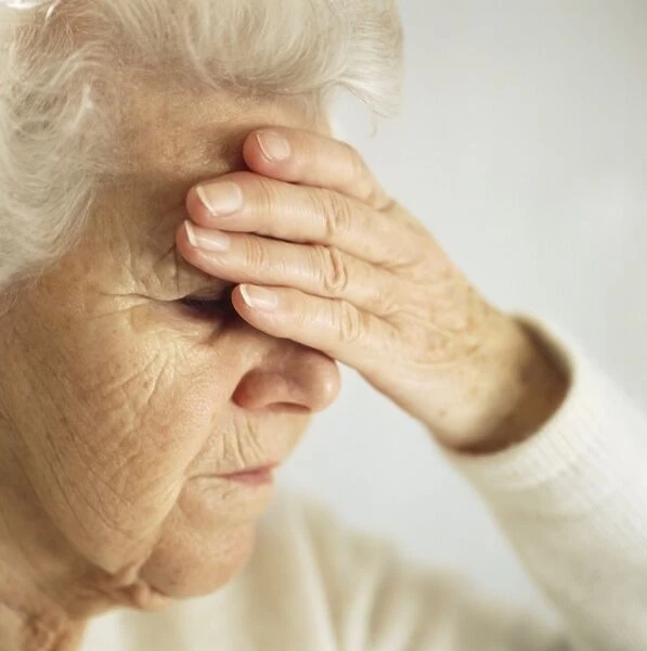 Headache. MODEL RELEASED. Headache. Elderly woman with a headache pressing her forehead