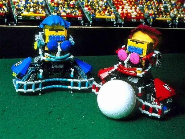 Two Lego footballers with a ball at RoboCup-98