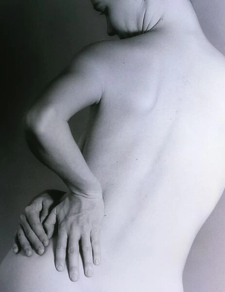 Posterior view of a naked woman with back pain