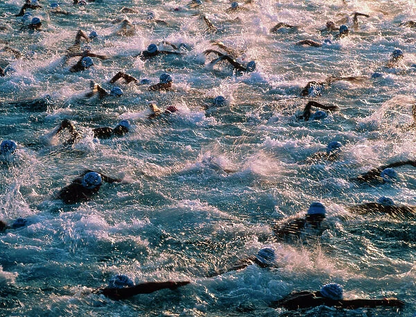 Triathlon swimmers. Men swimming in the Pacific Ocean during the Kona Ironman