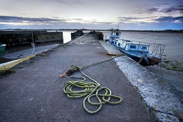 Beadnell Harbour at dusk showing old rope coiled For sale as