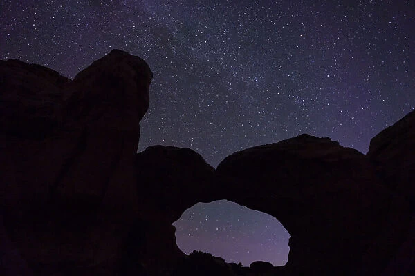 Starry sky viewed through Broken Arch, Arches National Park, Utah