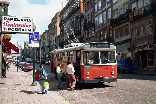Street scene of people getting on a trolley bus in