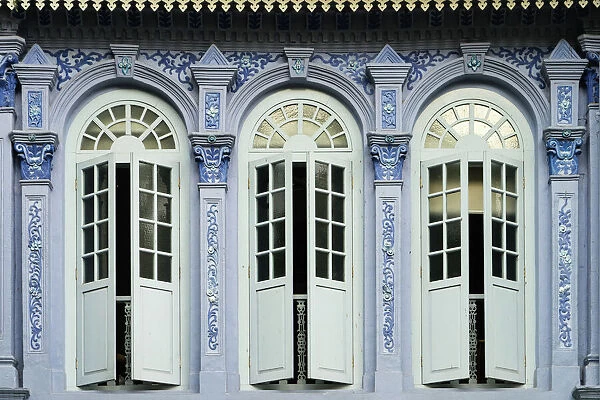 Traditional shophouse windows open out onto a street in the Orchard Road neighborhood in Singapore