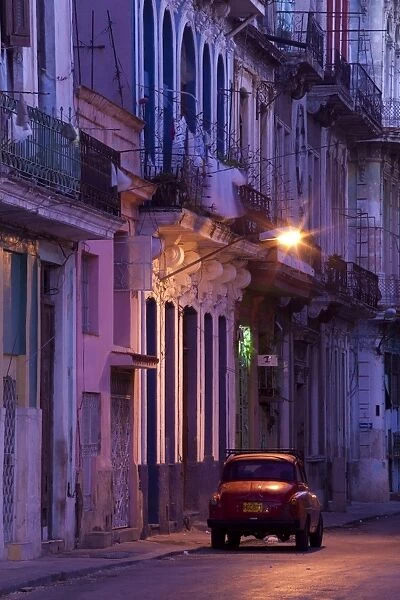 Vintage American car parked on floodlit street, predawn, Havana Centro, Cuba, West Indies, Central America