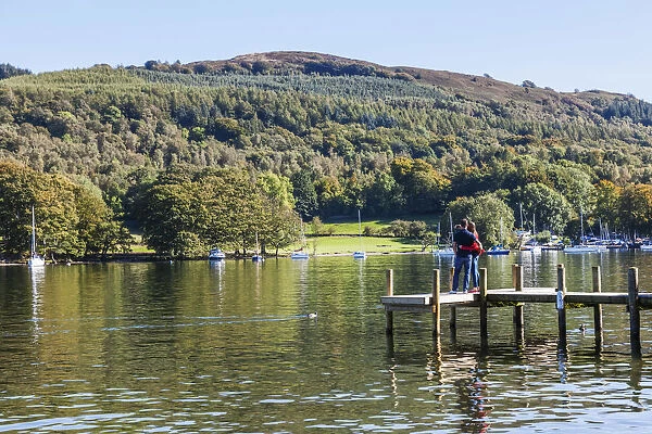 England, Cumbria, Lake District, Windermere, Lakeside, Couple on Wooden Jetty