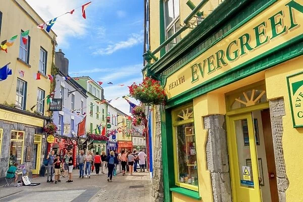 Europe, Dublin, Ireland, Tourists walking along Galway town streets and sitting