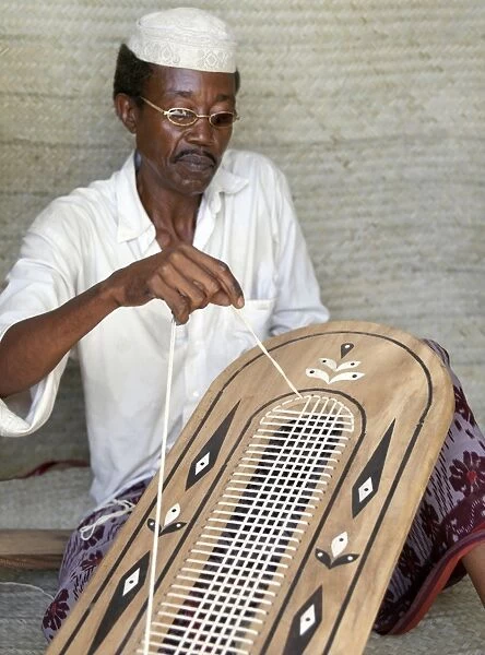 A Lamu man strings the back of a traditional Lamu-style