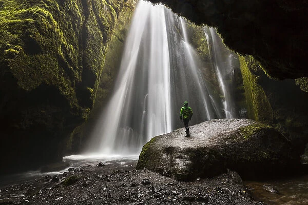 Man into a cave in front of a waterfall, Gljufrafoss, Skogar, Iceland, Northern Europe (MR)